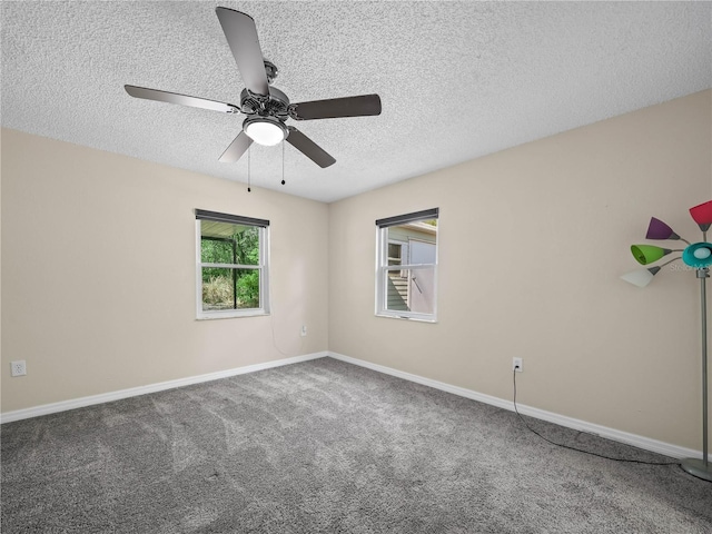 carpeted empty room featuring a ceiling fan, a textured ceiling, and baseboards