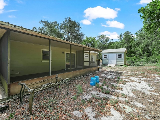 view of yard with a storage unit, an outbuilding, and a sunroom