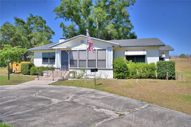 view of front of property featuring stucco siding and a front lawn