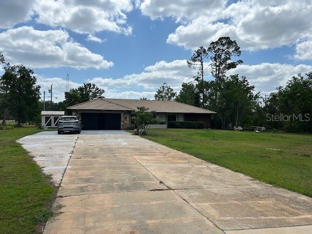 view of front of home with a garage, a front yard, and concrete driveway