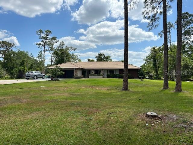 ranch-style home with a garage, a front yard, and concrete driveway
