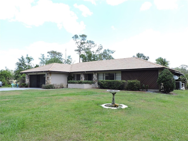 ranch-style home featuring a garage, driveway, and a front yard
