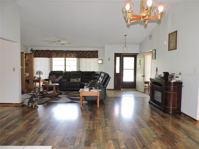 living area featuring visible vents, hardwood / wood-style floors, baseboards, high vaulted ceiling, and ceiling fan with notable chandelier