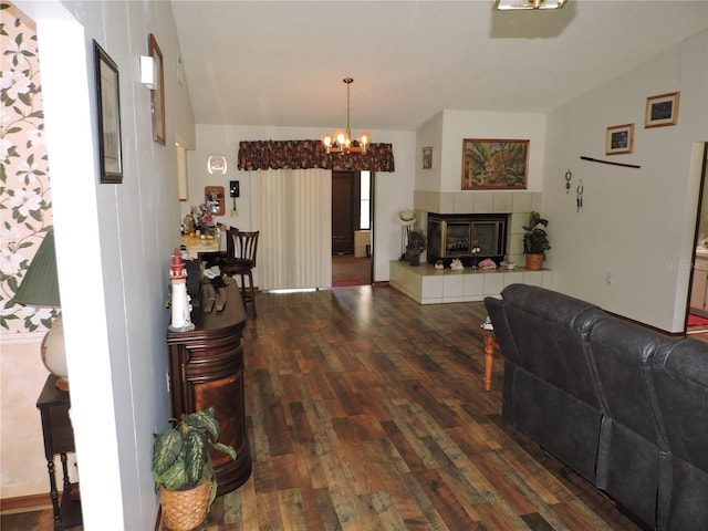 living area with an inviting chandelier, wood finished floors, and a tile fireplace