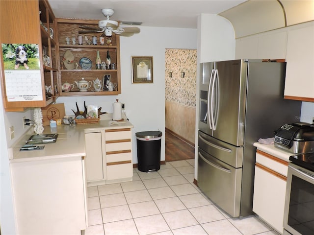 kitchen featuring light tile patterned flooring, appliances with stainless steel finishes, light countertops, a ceiling fan, and white cabinetry