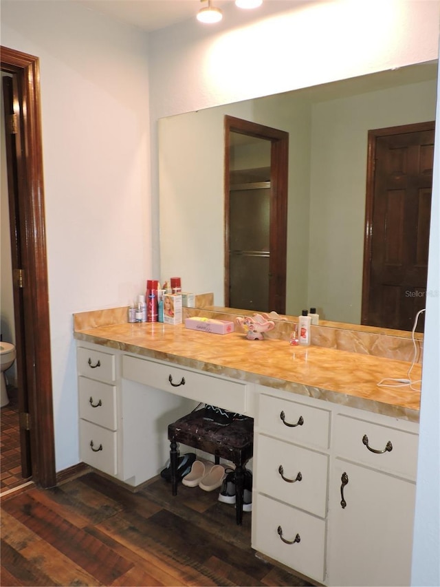 bathroom with toilet, wood finished floors, and vanity