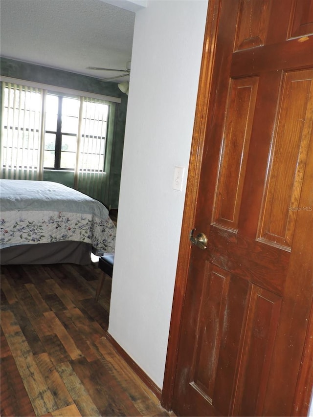 bedroom with dark wood-style flooring and baseboards