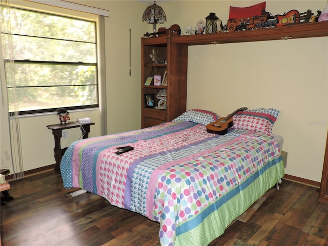 bedroom featuring baseboards and wood finished floors