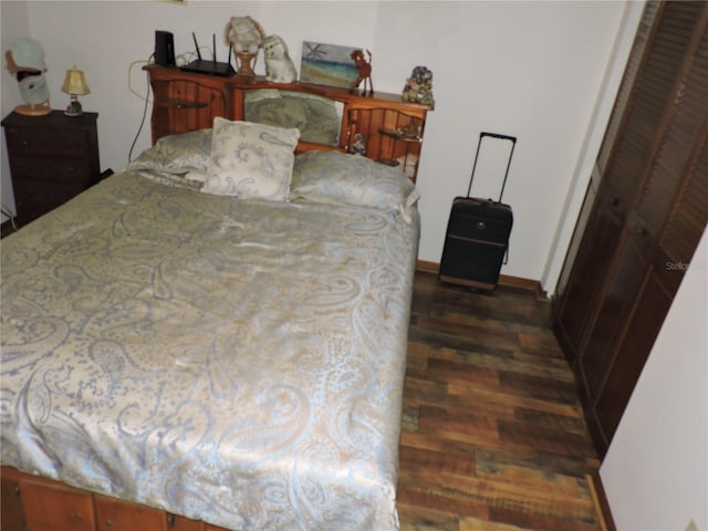 bedroom featuring dark wood-style flooring and baseboards