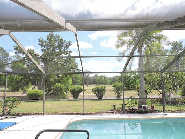 outdoor pool with a lawn, glass enclosure, and a patio