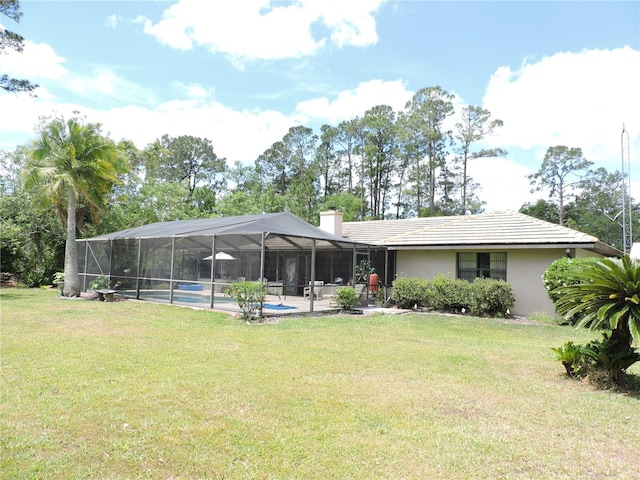 back of house featuring a patio, an outdoor pool, stucco siding, a chimney, and a lawn