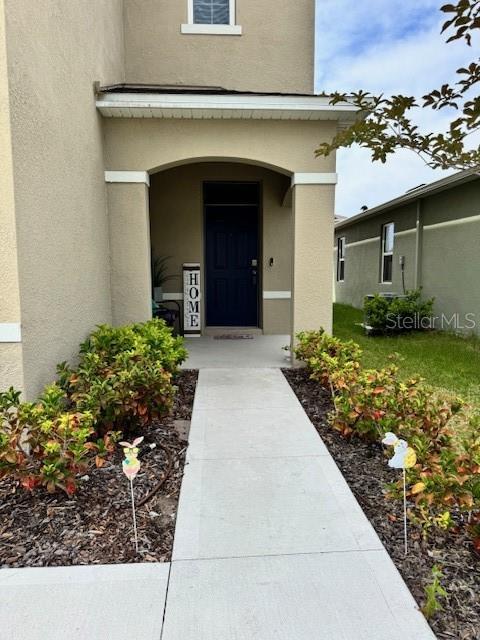 entrance to property featuring stucco siding