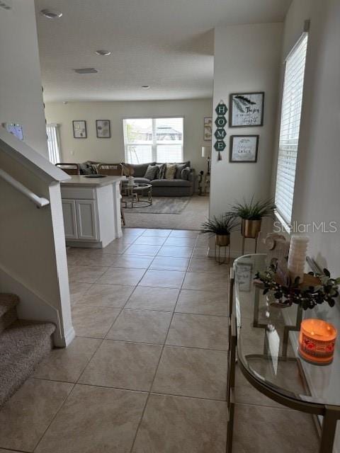 hall featuring stairs and light tile patterned floors