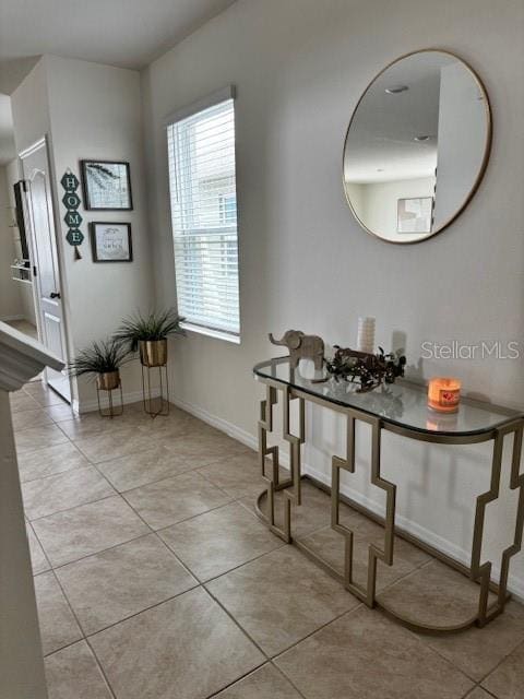 corridor with light tile patterned floors and baseboards
