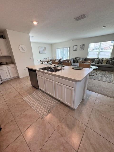 kitchen with a sink, dishwasher, a center island with sink, white cabinets, and plenty of natural light