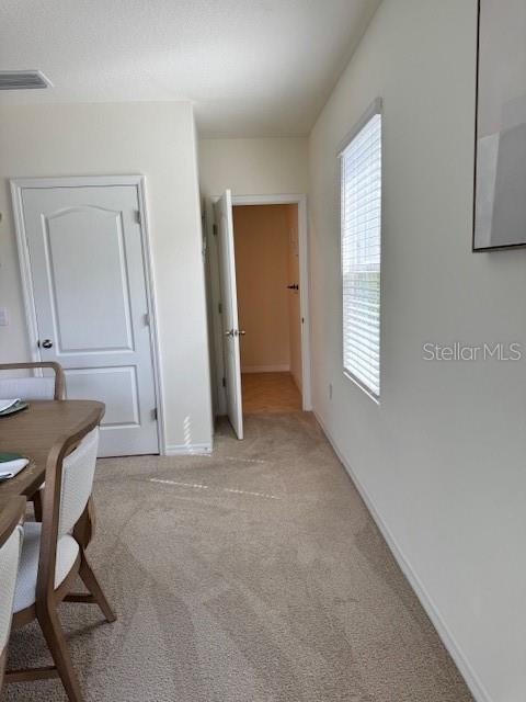 bedroom with light carpet and baseboards