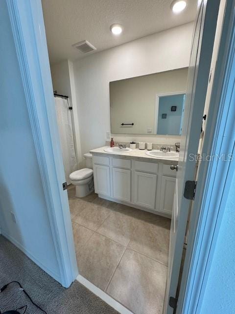 bathroom with double vanity, toilet, tile patterned flooring, and a shower with shower curtain