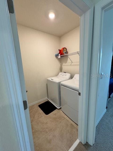 laundry room with independent washer and dryer, baseboards, and light tile patterned floors