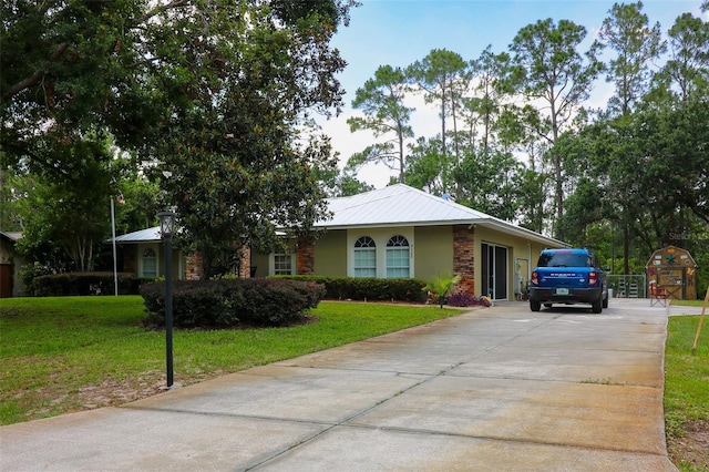 9365 Lemon Dr, Lake Wales, FL 33898 - ranch-style home with concrete driveway, a front yard, and metal roof