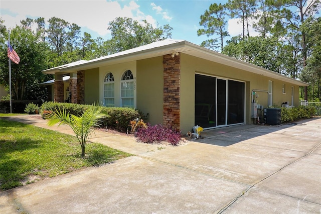 9365 Lemon Dr, Lake Wales, FL 33898 - view of property exterior featuring stucco siding, central AC, and stone siding