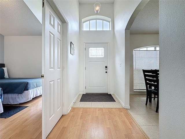 2200 Mallory Cir, Haines City, FL 33844 - foyer featuring arched walkways, light tile patterned flooring, baseboards, and a textured ceiling