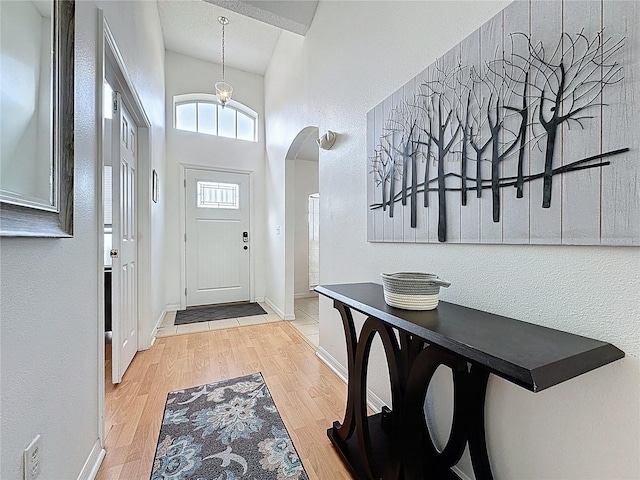2200 Mallory Cir, Haines City, FL 33844 - foyer featuring arched walkways, wood finished floors, baseboards, and a towering ceiling
