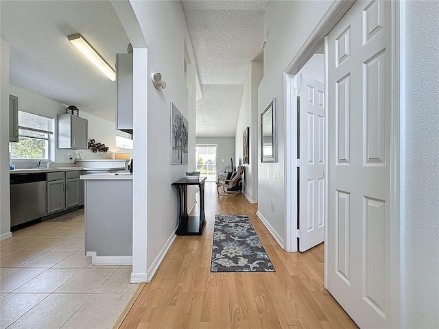 2200 Mallory Cir, Haines City, FL 33844 - hall with a textured ceiling, light wood-style flooring, baseboards, a sink, and arched walkways