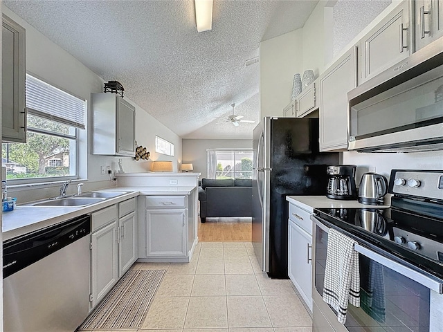 2200 Mallory Cir, Haines City, FL 33844 - kitchen with stainless steel appliances, a textured ceiling, a ceiling fan, light countertops, and a sink