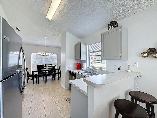 2200 Mallory Cir, Haines City, FL 33844 - kitchen featuring stainless steel appliances, a sink, a peninsula, light countertops, and a breakfast bar