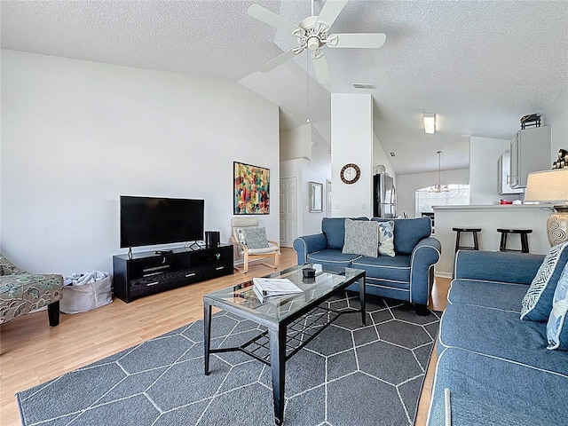 2200 Mallory Cir, Haines City, FL 33844 - living area featuring vaulted ceiling, a ceiling fan, wood finished floors, and a textured ceiling