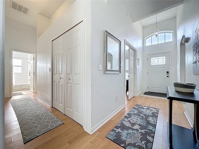 2200 Mallory Cir, Haines City, FL 33844 - foyer with high vaulted ceiling, light wood-style floors, baseboards, and a chandelier