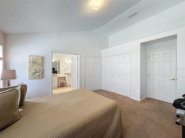 2200 Mallory Cir, Haines City, FL 33844 - bedroom with two closets, connected bathroom, a textured ceiling, light carpet, and baseboards