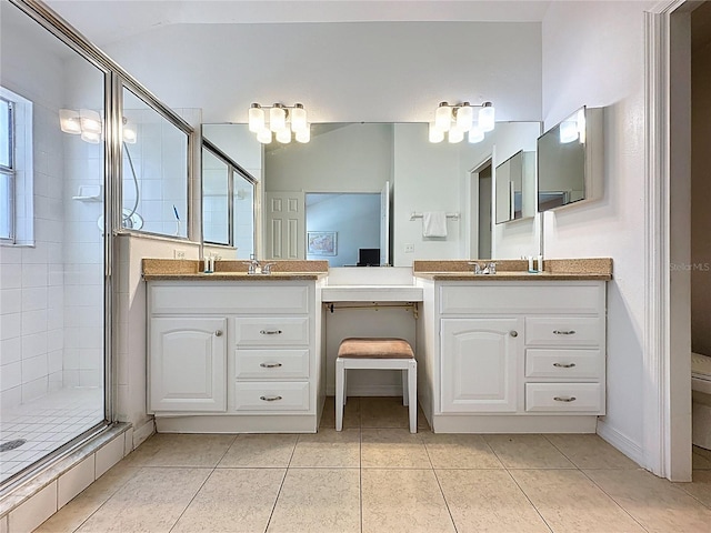 2200 Mallory Cir, Haines City, FL 33844 - bathroom featuring a shower stall, two vanities, tile patterned floors, and toilet