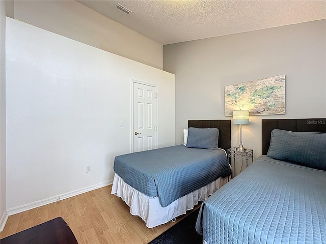 2200 Mallory Cir, Haines City, FL 33844 - bedroom with wood finished floors, lofted ceiling, baseboards, and a textured ceiling