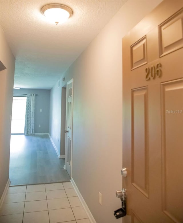 130 E Johnson Ave Unit 206, Lake Wales, FL 33853 - corridor with a textured ceiling, light tile patterned floors, and baseboards