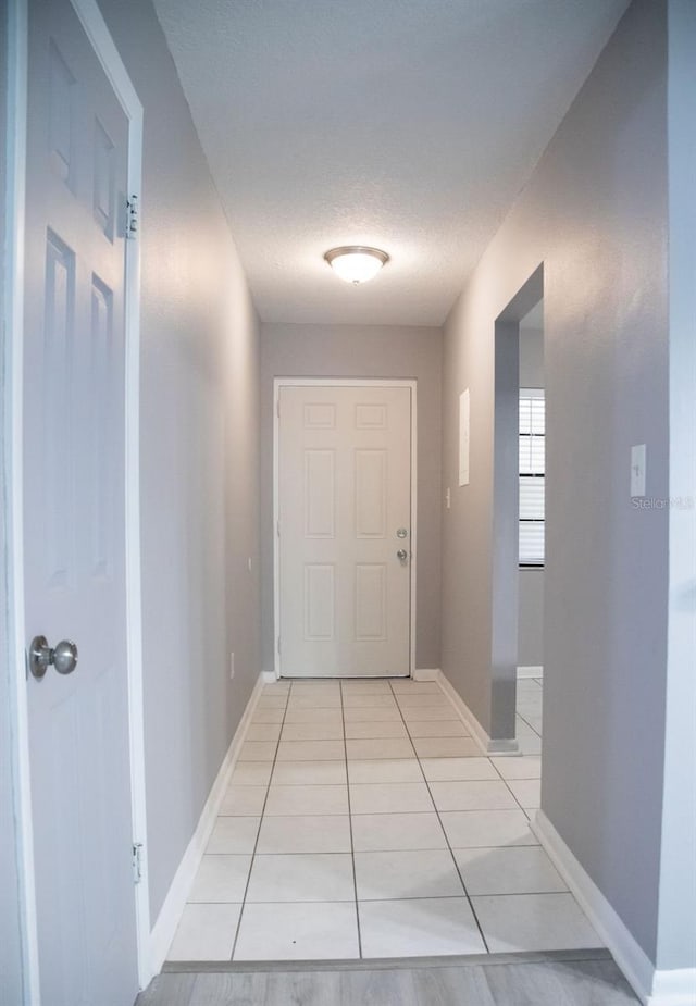 130 E Johnson Ave Unit 206, Lake Wales, FL 33853 - hall featuring light tile patterned floors, a textured ceiling, and baseboards