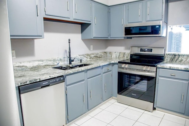 130 E Johnson Ave Unit 206, Lake Wales, FL 33853 - kitchen featuring appliances with stainless steel finishes, a sink, light countertops, light tile patterned floors, and blue cabinets