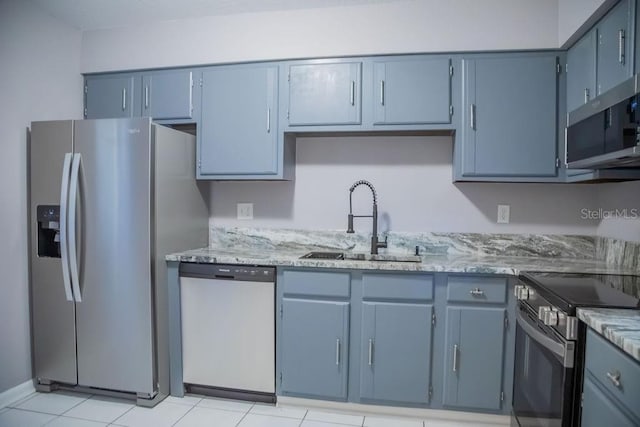 130 E Johnson Ave Unit 206, Lake Wales, FL 33853 - kitchen featuring appliances with stainless steel finishes, a sink, light stone counters, blue cabinets, and light tile patterned floors