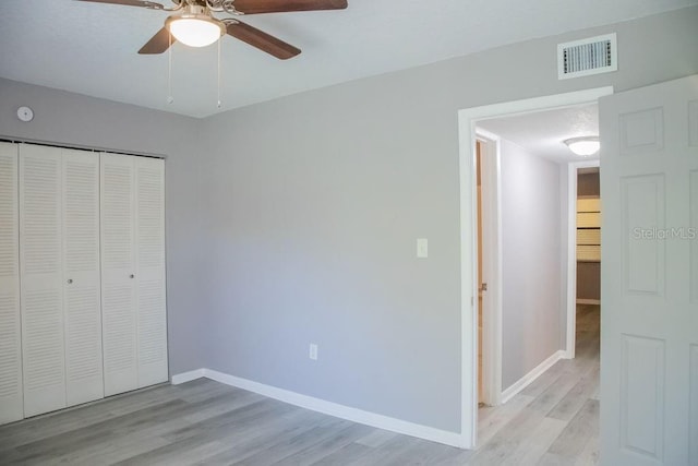 130 E Johnson Ave Unit 206, Lake Wales, FL 33853 - unfurnished bedroom featuring light wood-type flooring, baseboards, a closet, and a ceiling fan