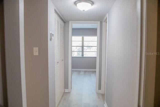 130 E Johnson Ave Unit 206, Lake Wales, FL 33853 - hall featuring a textured ceiling, light wood-type flooring, and baseboards
