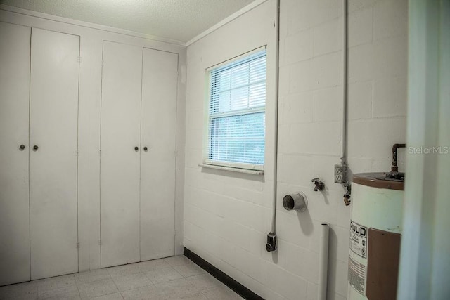 4725 Kayworth Rd, Lake Wales, FL 33898 - bathroom with electric water heater, concrete block wall, plenty of natural light, tile patterned floors, and a textured ceiling
