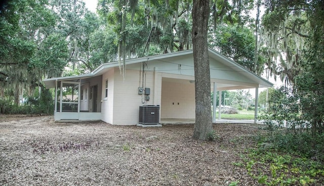 4725 Kayworth Rd, Lake Wales, FL 33898 - view of front facade with a sunroom, central air condition unit, a carport, and concrete block siding