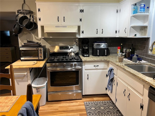 1422 Ave H SW, Winter Haven, FL 33880 - kitchen with under cabinet range hood, stainless steel appliances, a sink, and white cabinetry