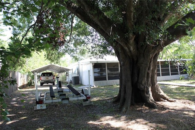 1422 Ave H SW, Winter Haven, FL 33880 - view of yard featuring a sunroom, central air condition unit, and a detached carport