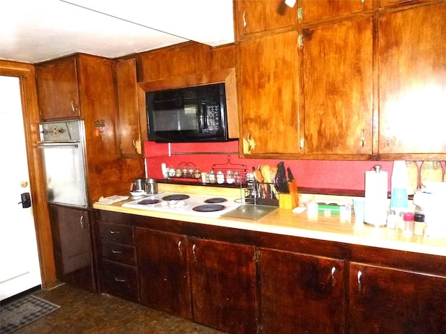 302 S Palm Ave, Frostproof, FL 33843 - kitchen with black microwave, white electric cooktop, wall oven, and light countertops