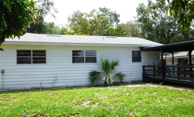 302 S Palm Ave, Frostproof, FL 33843 - view of home's exterior with a yard, roof with shingles, and a deck