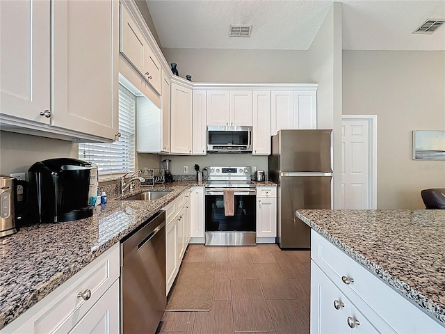 2696 Hemingway Ave, Haines City, FL 33844 - kitchen with stainless steel appliances, dark stone countertops, and white cabinets