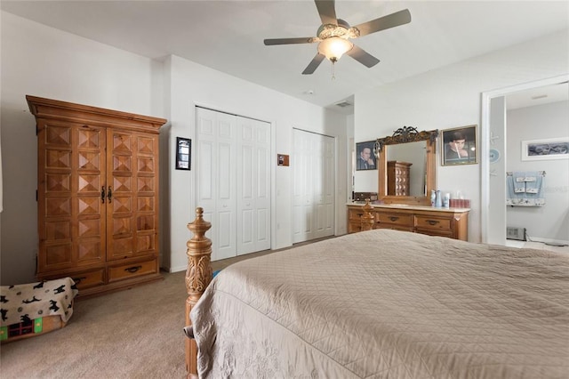 carpeted bedroom with two closets and ceiling fan