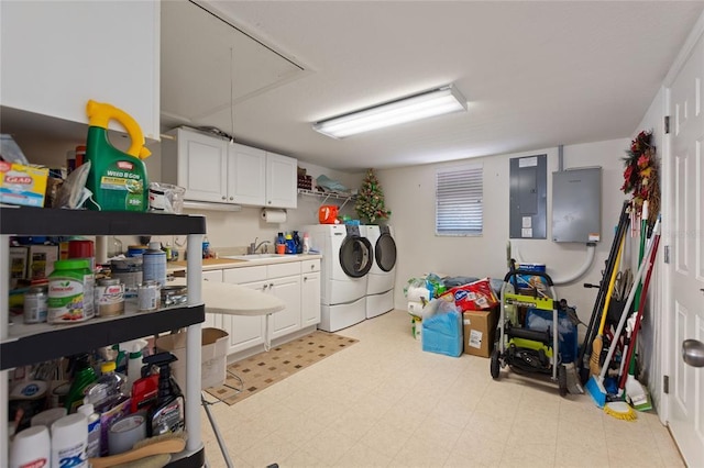 clothes washing area with sink, light tile floors, cabinets, and washer and clothes dryer