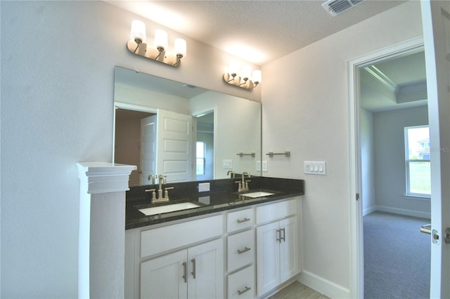 bathroom with vanity, a textured ceiling, and ornamental molding